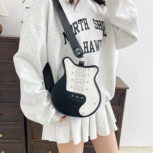 Guitar-shaped crossbody bag with contrast black and white panels and rivet details