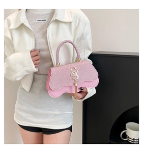Vue détaillée du sac à main rose pailleté avec rabat festonné et gland doré