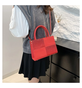 Détail du sac à main rouge avec motifs pailletés et pieds de protection en métal