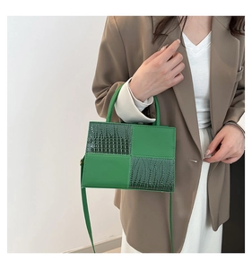 Détail du sac bandoulière vert avec mélange de cuir lisse et gaufré façon crocodile