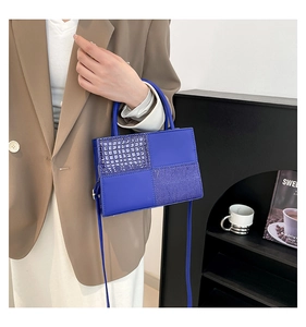 Détail du sac à main bleu en similicuir avec motif crocodile et poignées hautes
