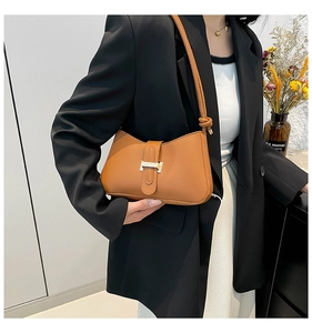 Détail du sac porté épaule vintage marron avec boucle en métal et bandoulière à nœud tissé