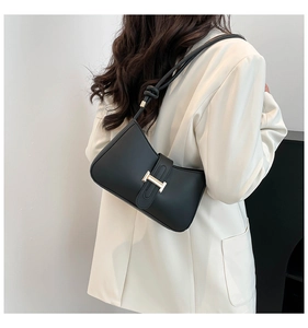 Détail du sac hobo noir avec une boucle métallique dorée en forme de H sur la bandoulière