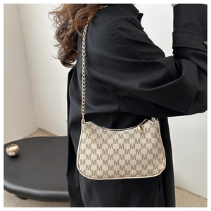 Close-up of beige crescent bag with M-letter print and elegant gold chain strap