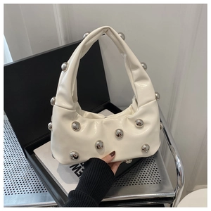 Detail of white crescent hobo bag with silver ball studs and ruched handle texture