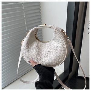Close-up of white woven leather hobo bag with gold hardware and curved handle