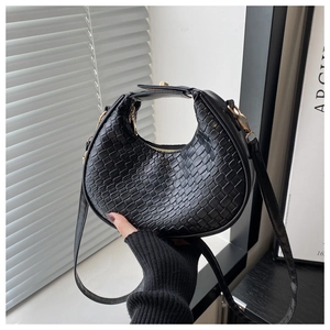 Detailed view of black woven faux leather hobo bag with gold metal hardware and zipper