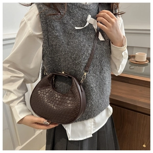 Gros plan détaillé du sac bandoulière demi-lune marron foncé avec texture crocodile