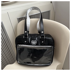 Détail du sac ita noir avec grande fenêtre PVC et plaque logo coeur argentée