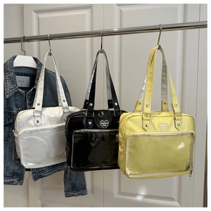 Trois sacs à main en similicuir brillant blanc, noir et jaune avec pochette coeur transparente
