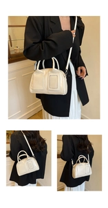 Détails d'un sac Boston en cuir beige porté avec une tenue urbaine élégante