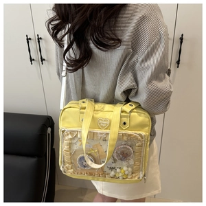 Sac Ita jaune avec fenêtre transparente montrant des badges anime sur un sac en nylon