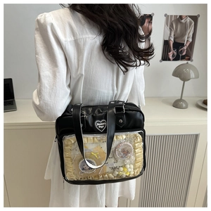 Détail d'un sac Ita noir en PU avec badge coeur et fenêtre transparente pour objets animés