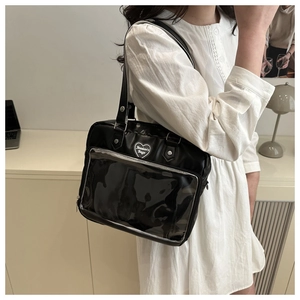 Gros plan sur le badge coeur et la fenêtre transparente en PVC du sac ita noir