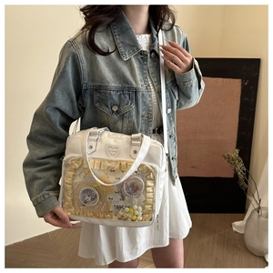 Détail du sac Ita blanc avec fenêtre transparente en PVC et bordures à volants crème