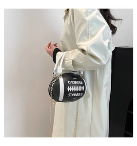 Detail of creative football-shaped handbag with white stitching and gold chain strap