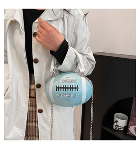 Detail of light blue rugby shaped crossbody bag with chain strap and white handle
