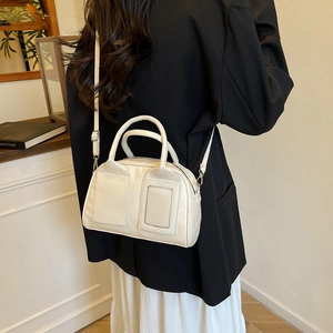 Chic beige Boston handbag in glossy faux leather with silver hardware and shoulder strap