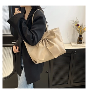 Gros plan du grand sac cabas beige avec nœud décoratif et texture cuir pour le travail