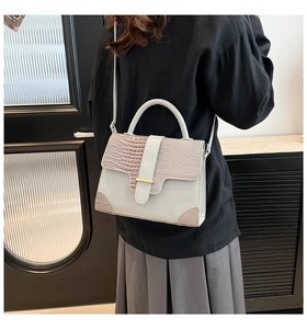 Détail du sac à main bleu clair avec motif crocodile et boucle dorée