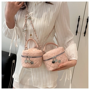 Détail du mini sac rose matelassé avec chaîne argentée et breloques camélia