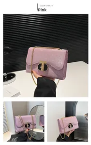 Vue macro de la texture pailletée rose avec chaîne dorée et fermoir rotatif du sac