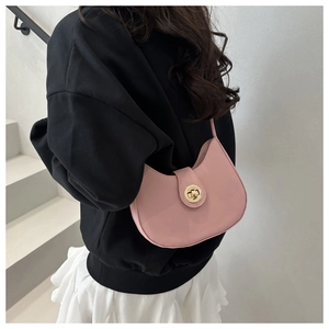Detailed view of pink leather crescent hobo bag with gold twist lock on model back
