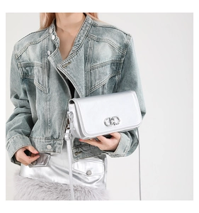 Detailed view of silver metallic leather flap bag with decorative interlocked CD logo clasp
