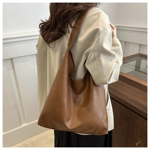 Close-up of brown matte faux leather tote bag showing natural grain texture and large capacity