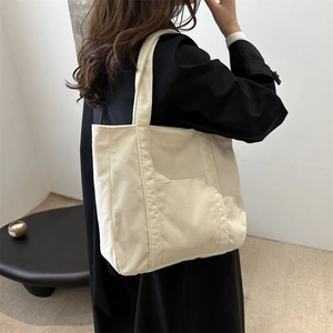 Large cream corduroy tote bag for women showing a stylish side view with model