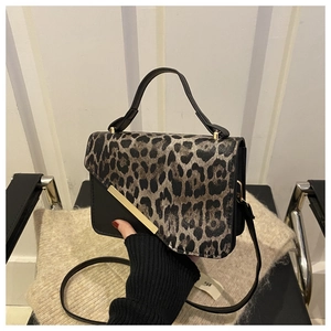 Détail du sac léopard avec garniture métallique dorée et bandoulière en cuir