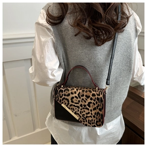 Sac bandoulière tendance à motif léopard avec boucle dorée porté par un mannequin