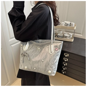 Sac fourre-tout plissé argenté avec perles et détail cœur porté par un mannequin