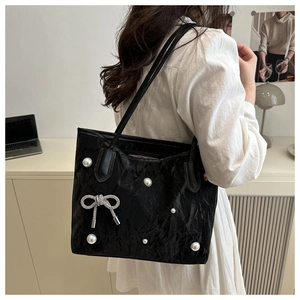 Détail du sac cabas noir avec perles et nœud strass sur cuir verni froissé