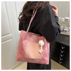 Dettaglio borsa tote trapuntata rosa con tracolla intrecciata e ciondolo di peluche
