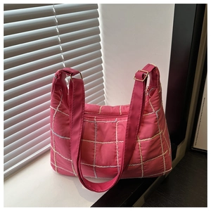 Detail of rose red quilted tote bag with cross-stitch patterns and gold metal buckle