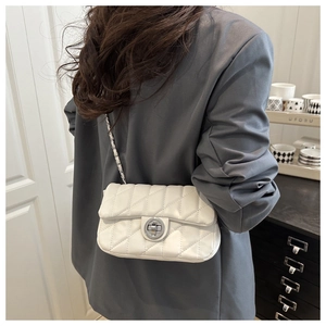 Vue arrière d'un petit sac bandoulière blanc matelassé avec chaîne sur une veste grise