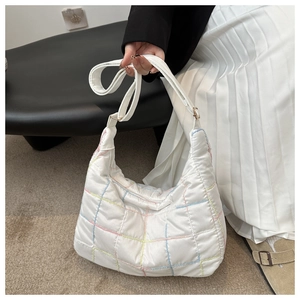 Detail of white quilted nylon tote with colorful macaron stitching on adjustable strap