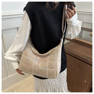 Detailed look at beige nylon hobo bag featuring colorful grid quilting and wide shoulder strap