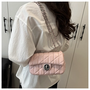 Chic pink quilted crossbody bag with silver chain strap worn over a woman's shoulder