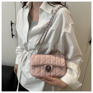 Detailed shot of pink quilted crossbody bag with metal chain strap and twist lock
