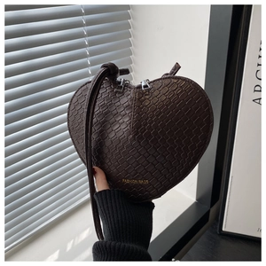 Detail of heart-shaped crossbody bag with crocodile texture and fashion logo