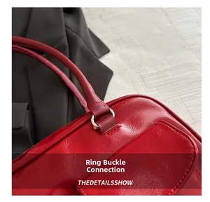 Detail of red wax leather handbag showing silver ring buckle connection and texture
