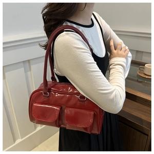 Primo piano della borsa a spalla in pelle verniciata rossa con doppie tasche anteriori
