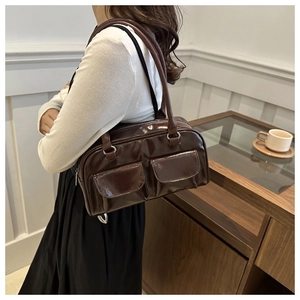 Dettaglio di una borsa quadrata in pelle verniciata marrone scuro con doppie tasche