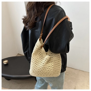 Detailed macro view of the beige crochet hobo bag showing woven texture and leather strap