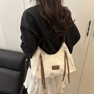 Fashionable beige hobo bag with cloud texture and brown straps shown on a model