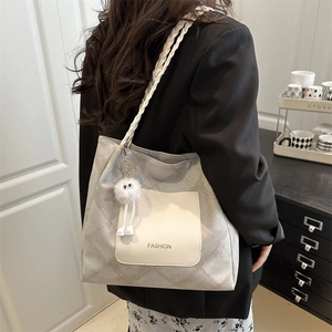 Light grey quilted tote bag with white braided shoulder straps and cute plush pendant