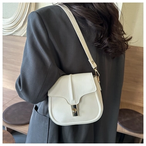 Detail of off-white leather shoulder bag with gold metal buckle on grey blazer