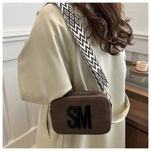 Sac caméra en daim marron avec logo SM embossé et large bandoulière géométrique
